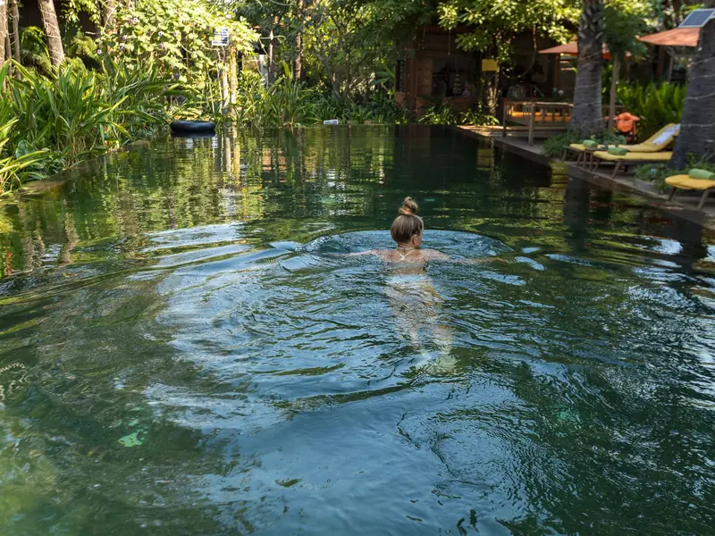 Depois: piscina natural cercada de vegetação e água limpa